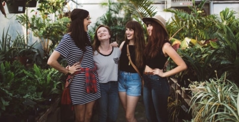 4 Frauen stehen nebeneinander und lachen