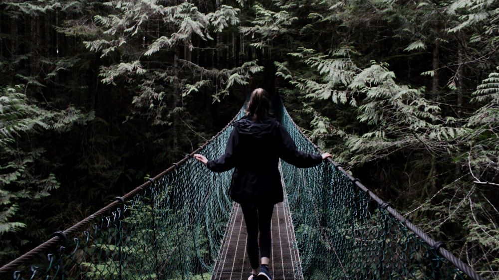 Frau auf Brücke mit Blick in den Dschungel